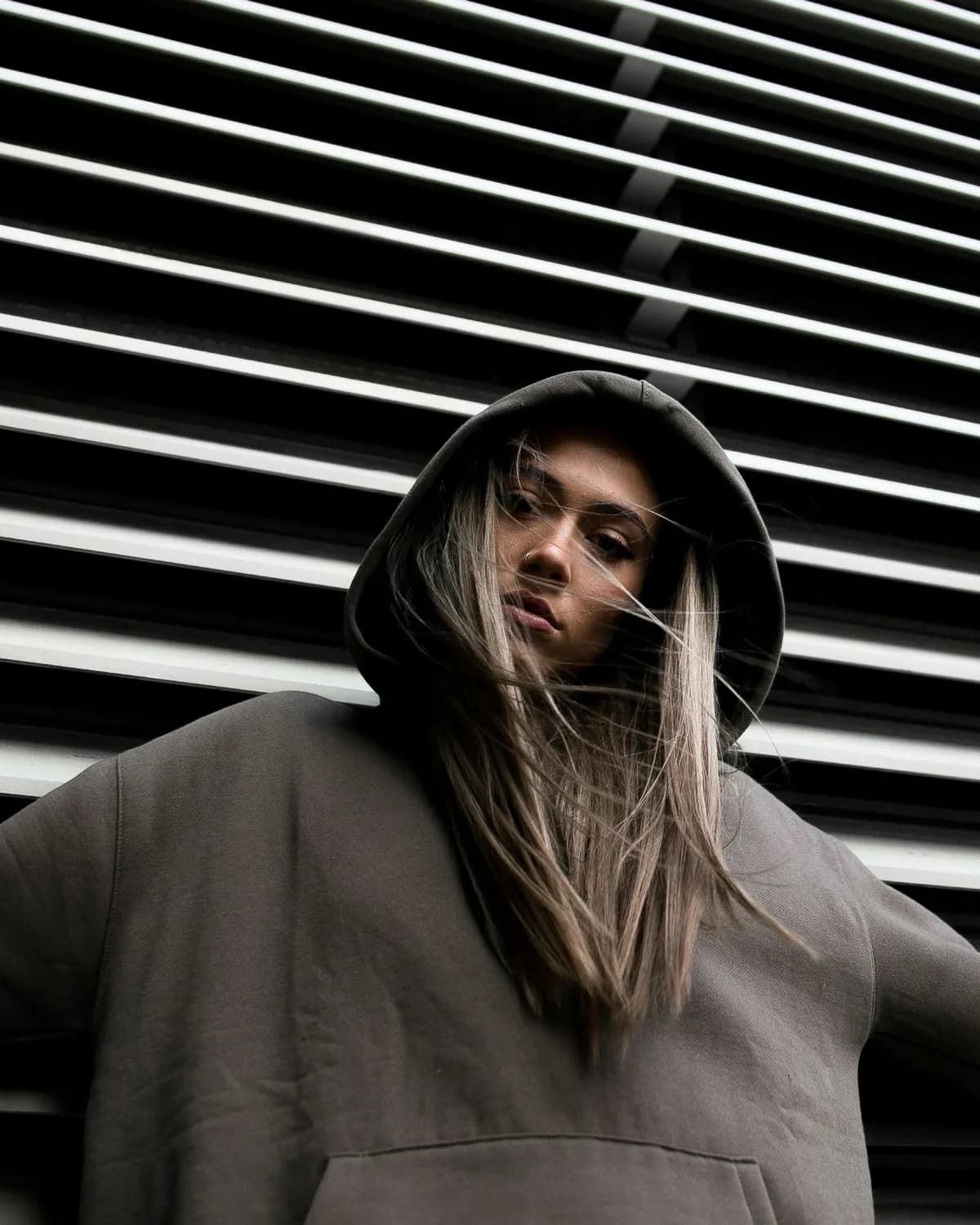A woman in a plain grey hoodie with the hood up
