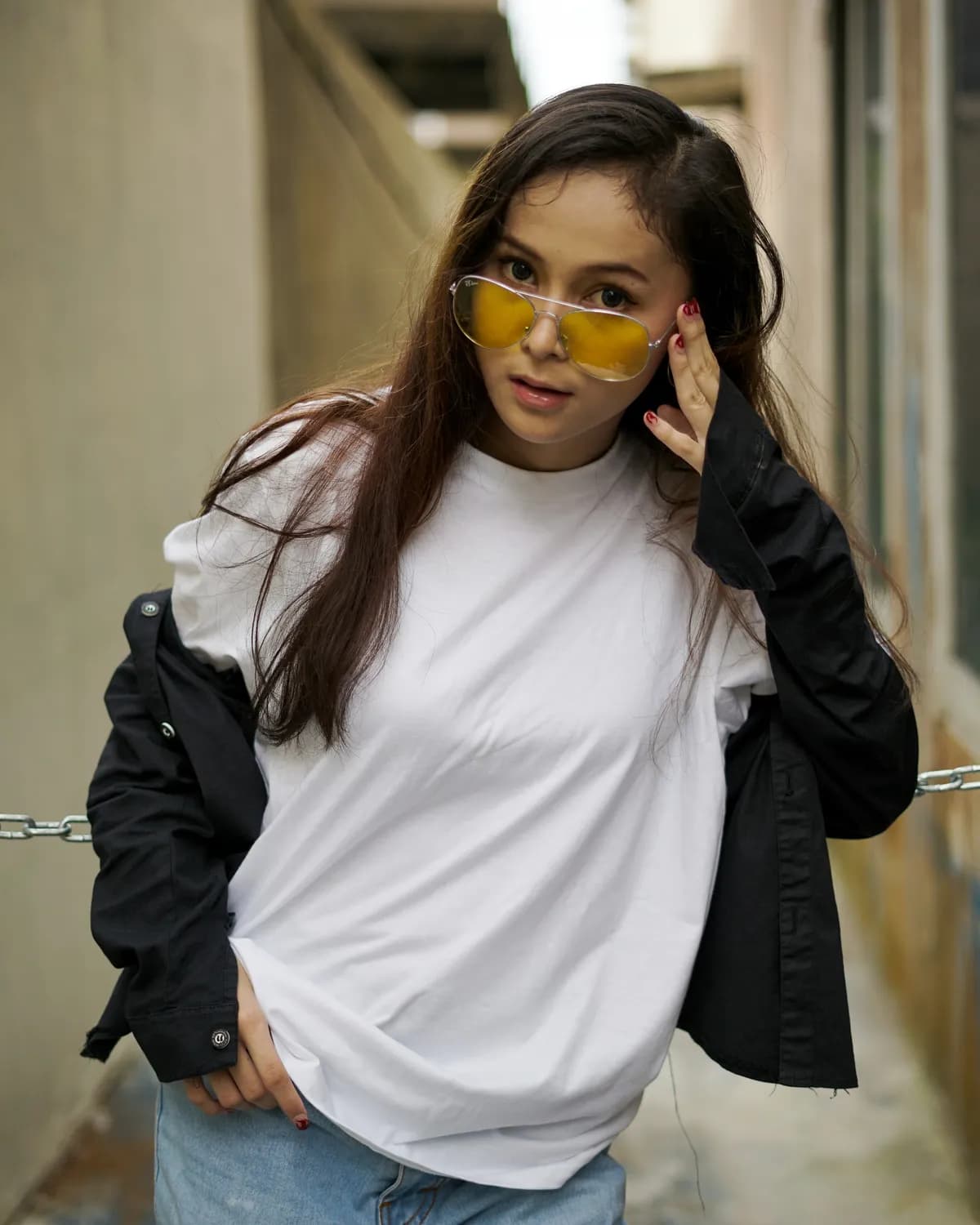 A woman in a plain white oversized tee and a black jacket